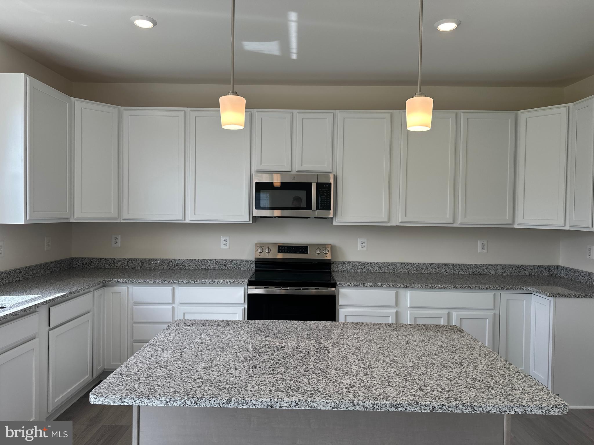 60 Chase Circle Elkton, MD 21921 - Photo 15 of 48 a kitchen with granite countertop a stove and a white cabinets