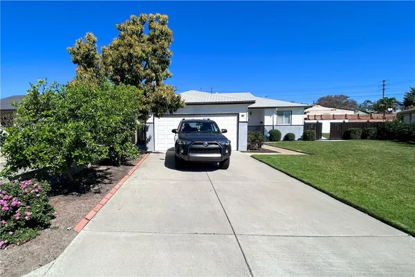 a car parked in front of a house with a yard