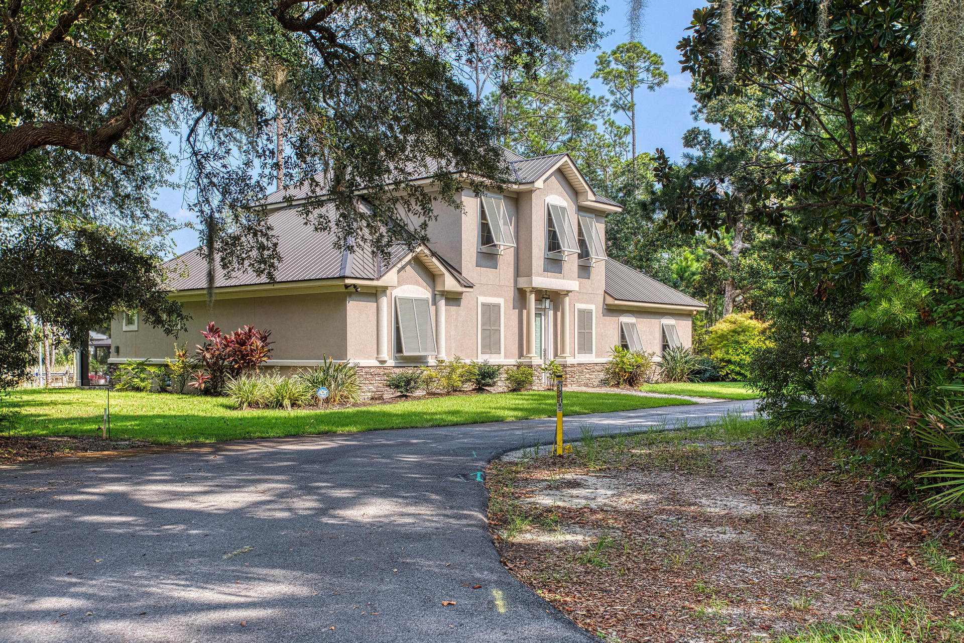 160 Grand Flora Way Santa Rosa Beach, FL 32459 - Photo 2 of 51 a front view of a house with a yard and trees