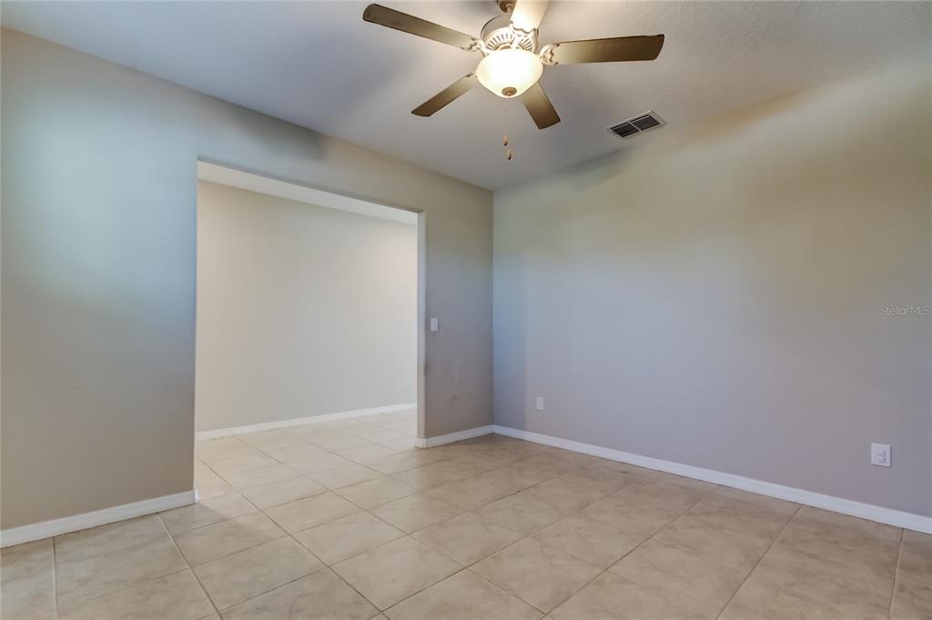 6362 Spider Lily Way New Port Richey, FL 34653 - Photo 13 of 47 an empty room with a chandelier fan and windows