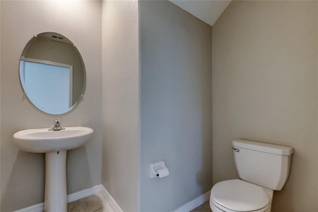6362 Spider Lily Way New Port Richey, FL 34653 - Photo 15 of 47 a bathroom with a toilet sink and mirror