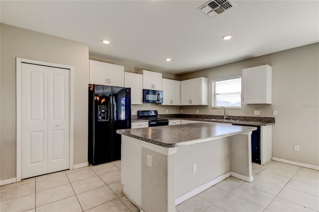 6362 Spider Lily Way New Port Richey, FL 34653 - Photo 19 of 47 a kitchen with stainless steel appliances granite countertop a sink and a refrigerator