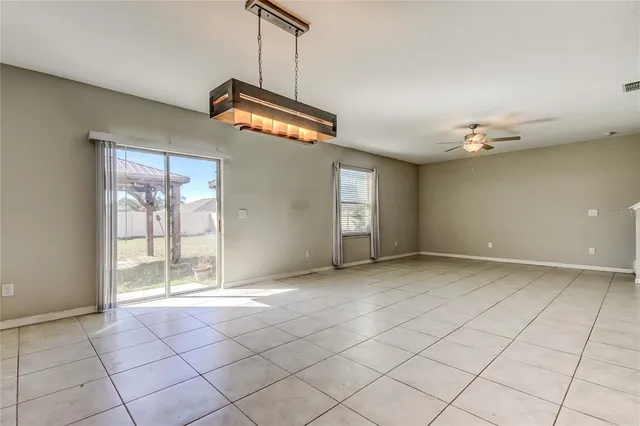 an empty room with a ceiling fan and entryway