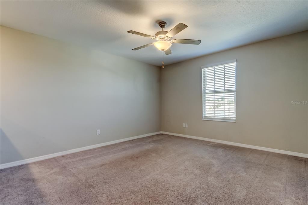 6362 Spider Lily Way New Port Richey, FL 34653 - Photo 26 of 47 an empty room with windows and fan