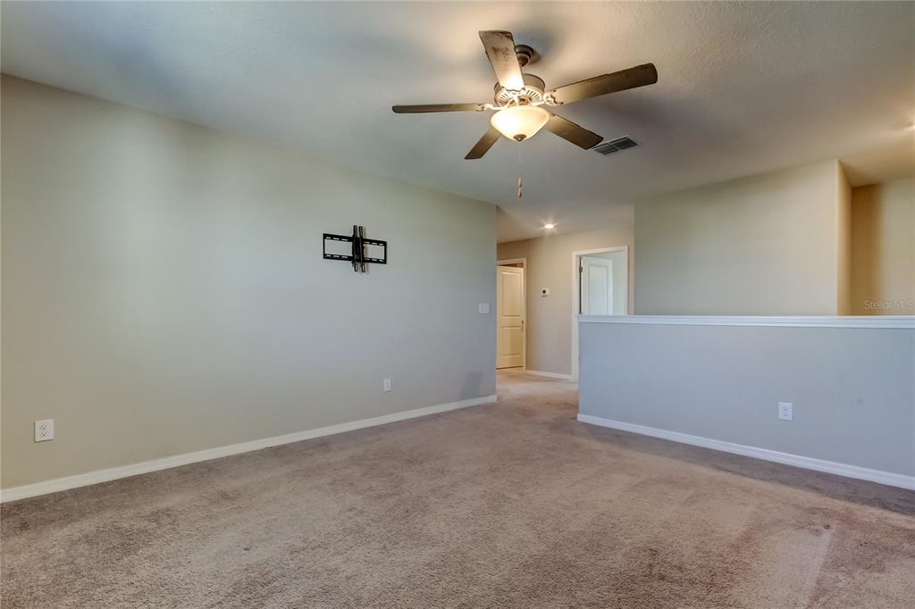 6362 Spider Lily Way New Port Richey, FL 34653 - Photo 28 of 47 an empty room with a ceiling fan and a window