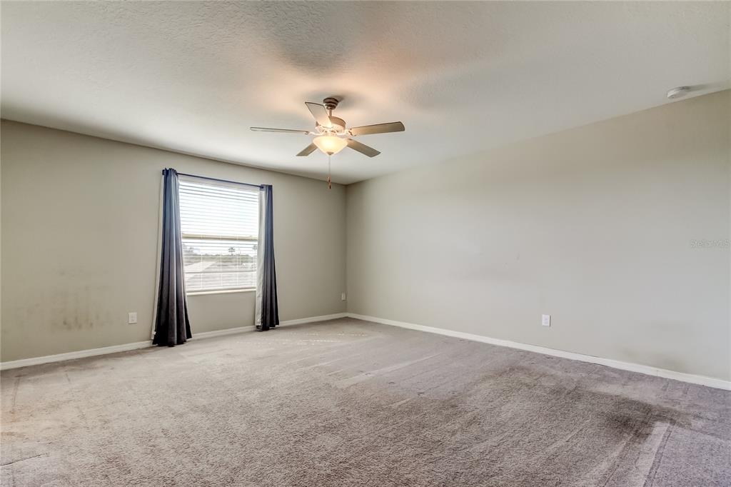 6362 Spider Lily Way New Port Richey, FL 34653 - Photo 29 of 47 an empty room with a window and ceiling fan