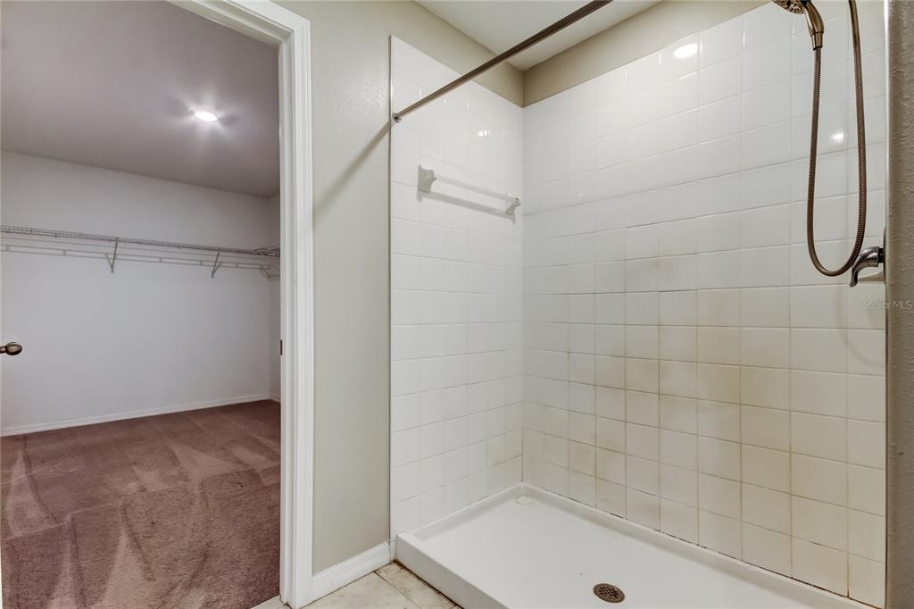 6362 Spider Lily Way New Port Richey, FL 34653 - Photo 32 of 47 a bathroom with a glass shower door