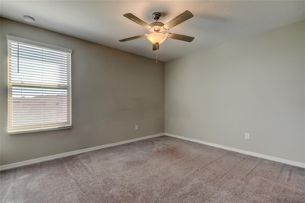 6362 Spider Lily Way New Port Richey, FL 34653 - Photo 36 of 47 an empty room with a chandelier fan and windows
