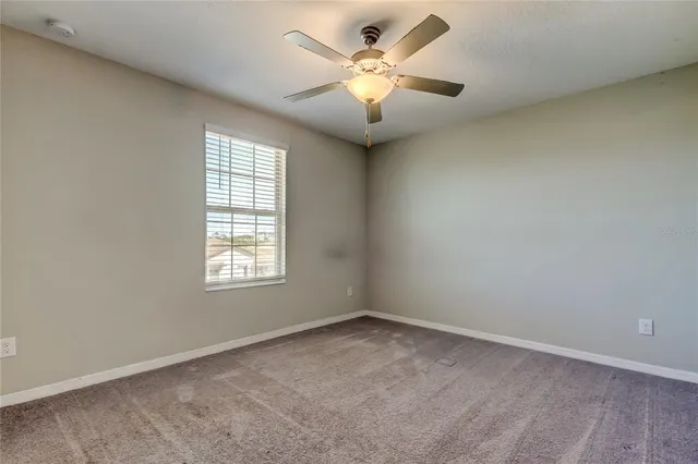 an empty room with a ceiling fan and a fan