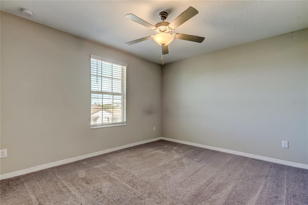 6362 Spider Lily Way New Port Richey, FL 34653 - Photo 41 of 47 an empty room with a chandelier fan and windows