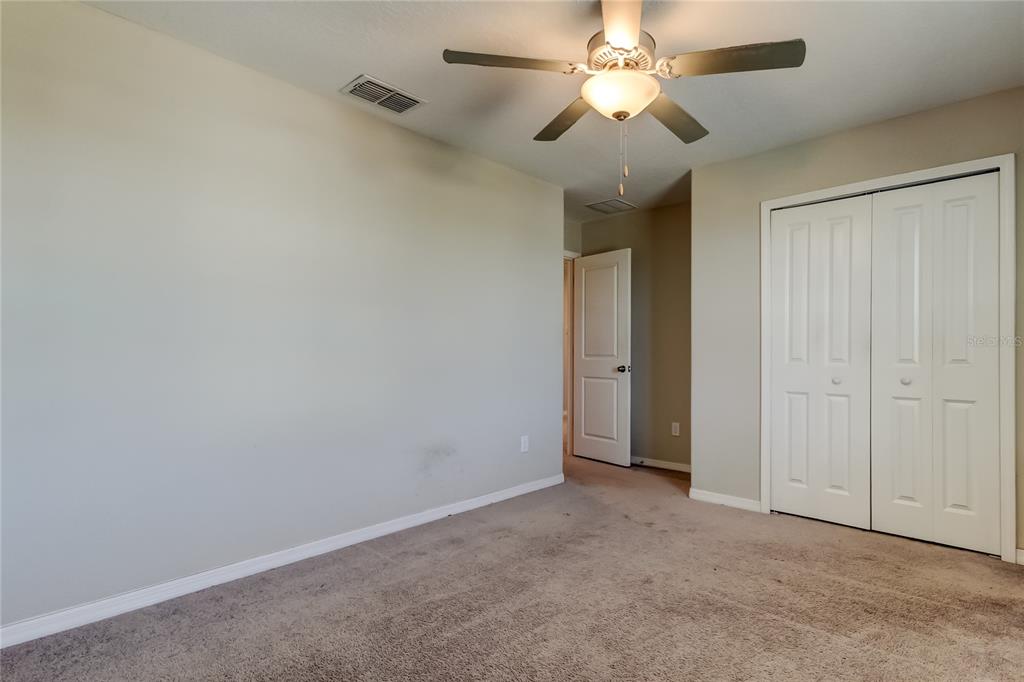 6362 Spider Lily Way New Port Richey, FL 34653 - Photo 42 of 47 an empty room with a ceiling fan and a fan