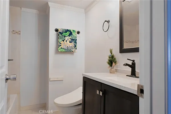 a bathroom with a granite countertop toilet sink and mirror