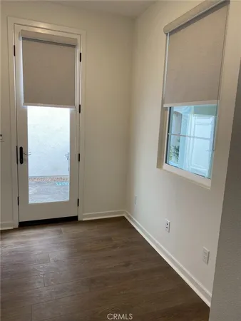 an empty room with wooden floor and mirror