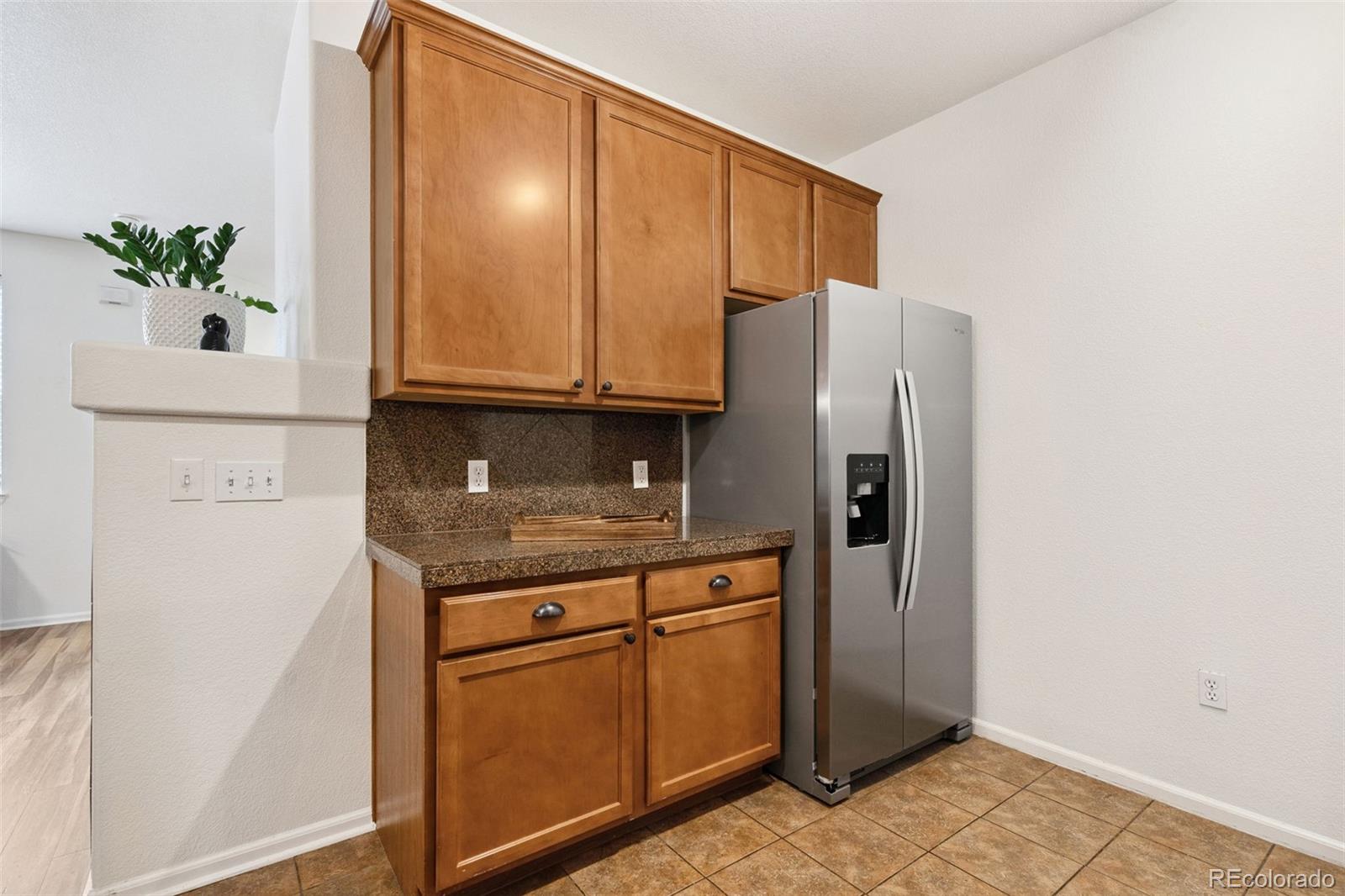 7140 Simms Street, Unit 102 Arvada, CO 80004 - Photo 11 of 34 a kitchen with stainless steel appliances granite countertop a refrigerator a stove and a cabinets