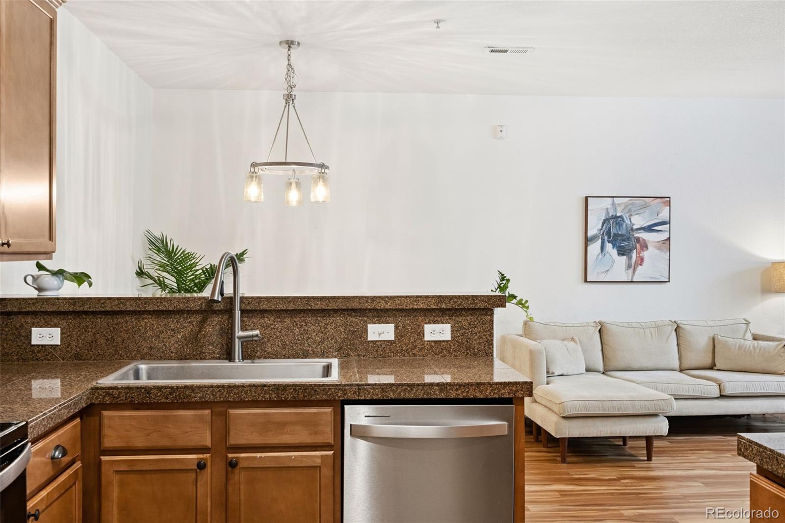 7140 Simms Street, Unit 102 Arvada, CO 80004 - Photo 12 of 34 a living room with a sink and a potted plant