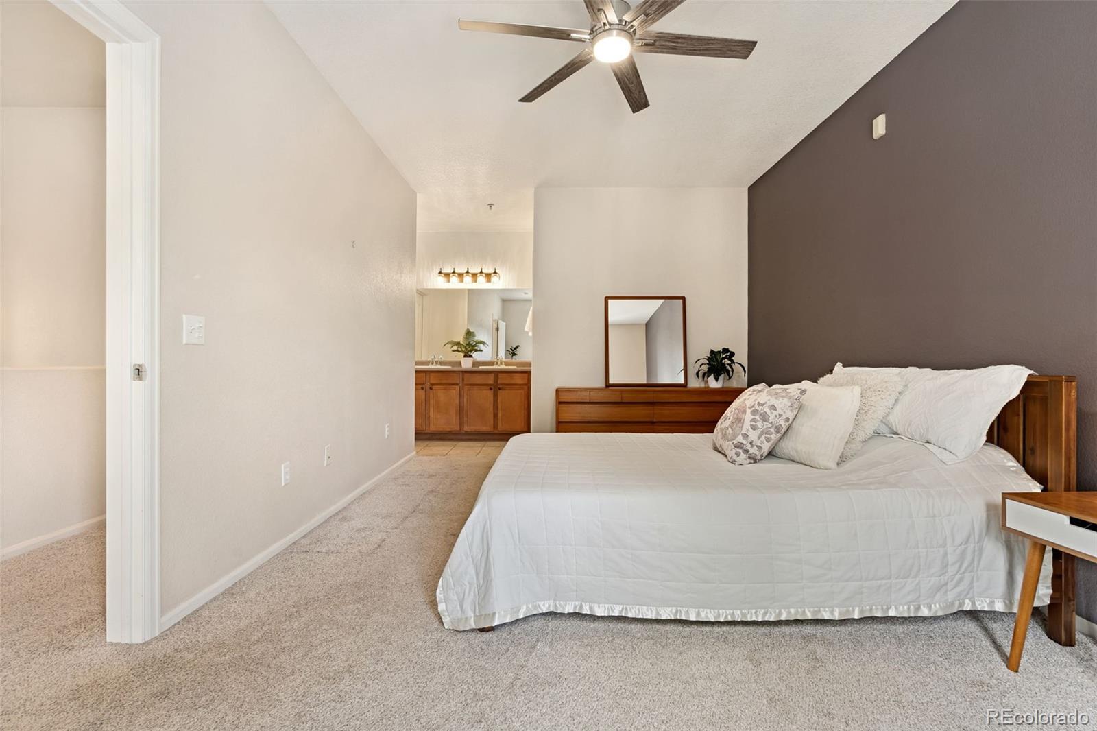 7140 Simms Street, Unit 102 Arvada, CO 80004 - Photo 16 of 34 a bedroom with a bed and a chandelier