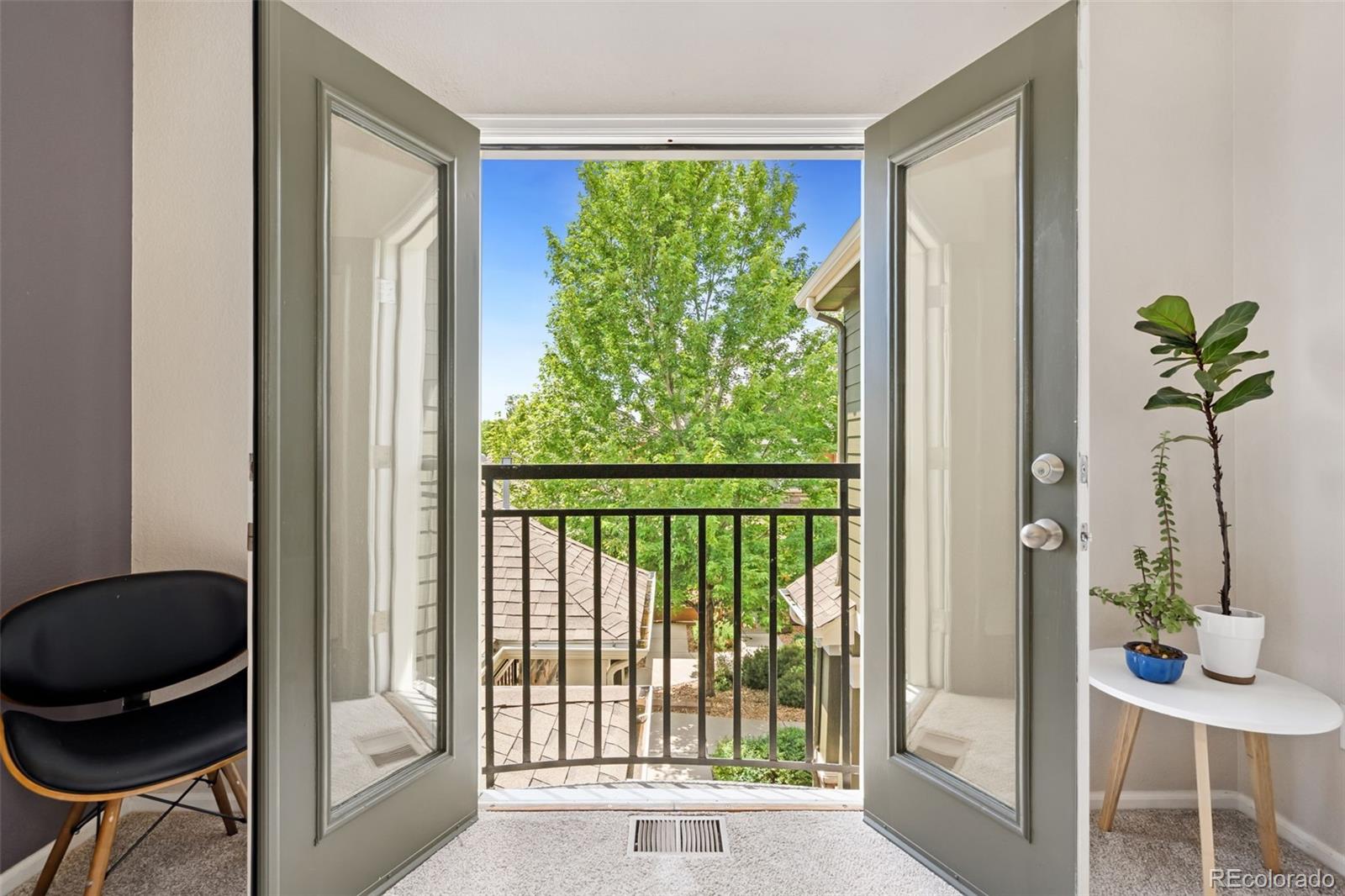 7140 Simms Street, Unit 102 Arvada, CO 80004 - Photo 19 of 34 a view of a balcony with chair and potted plant