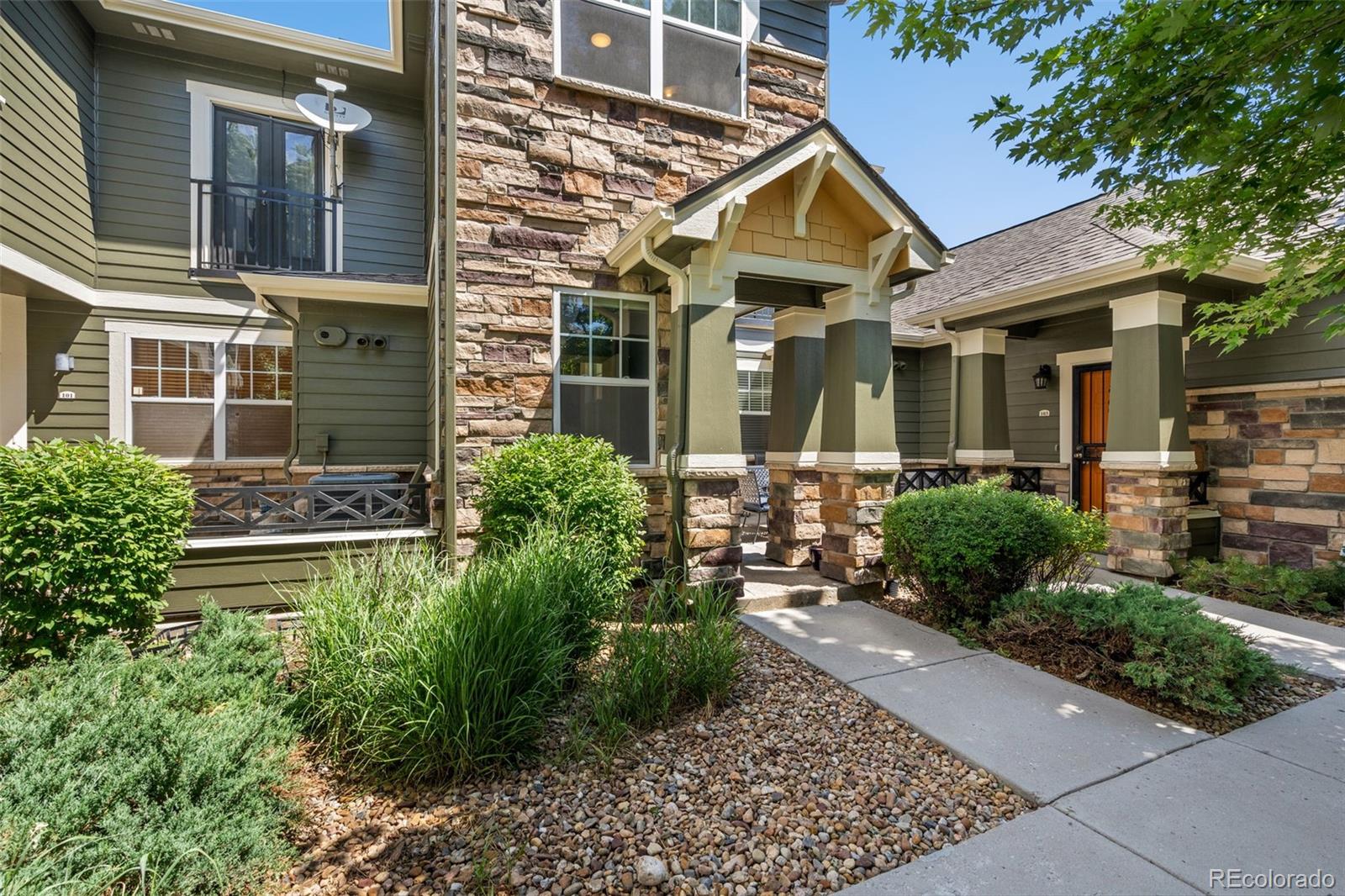 7140 Simms Street, Unit 102 Arvada, CO 80004 - Photo 2 of 34 front view of a house with a yard