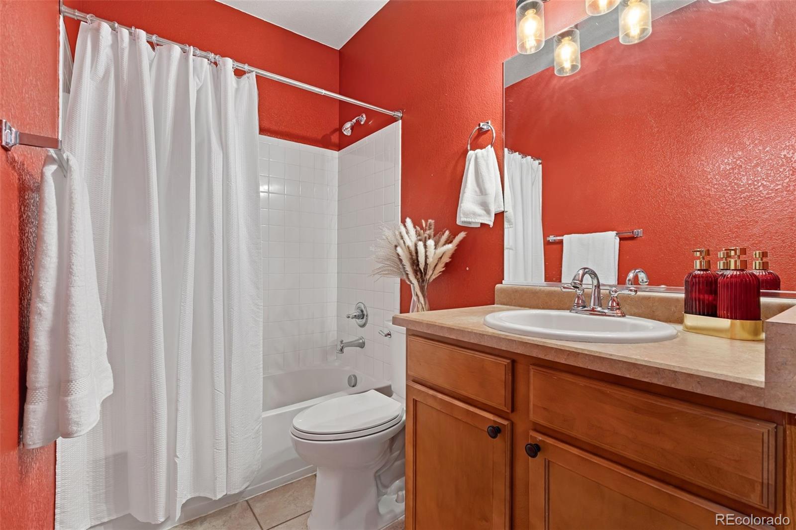 7140 Simms Street, Unit 102 Arvada, CO 80004 - Photo 23 of 34 a bathroom with a sink a toilet and shower curtain