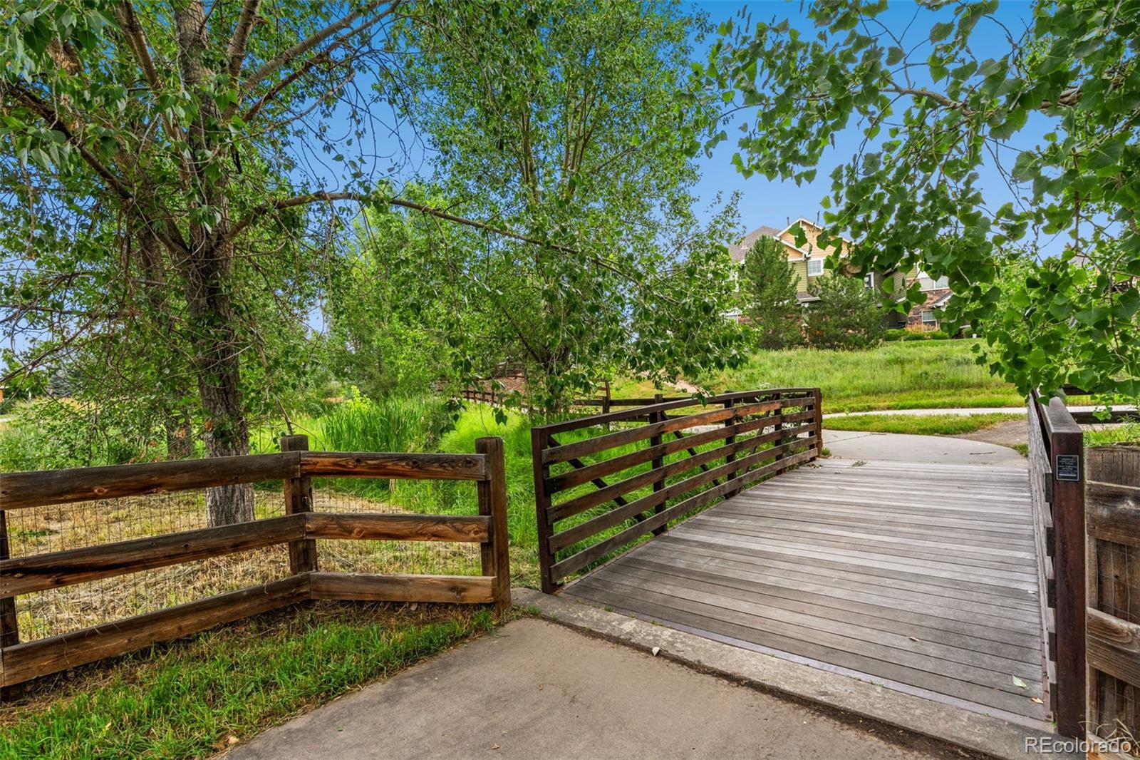 7140 Simms Street, Unit 102 Arvada, CO 80004 - Photo 26 of 34 a view of a wooden deck and a yard