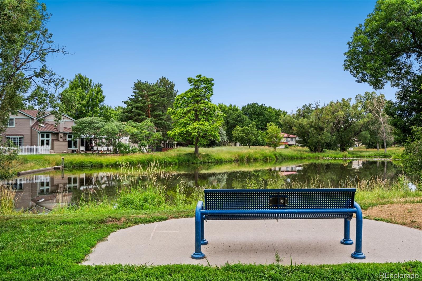 7140 Simms Street, Unit 102 Arvada, CO 80004 - Photo 28 of 34 a view of lake with a bench in a lake