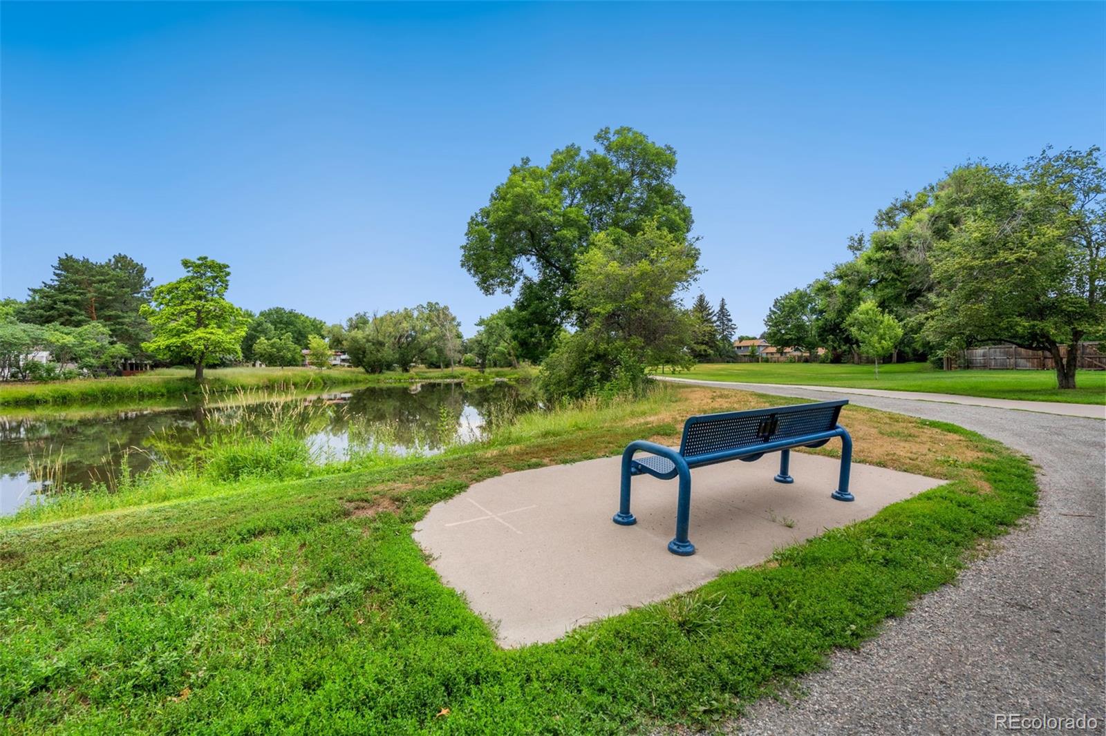 7140 Simms Street, Unit 102 Arvada, CO 80004 - Photo 29 of 34 a view of a lake with outdoor space and a bench