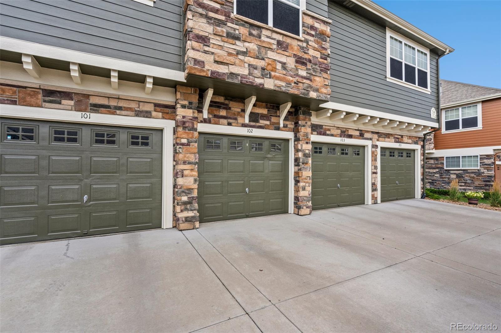 7140 Simms Street, Unit 102 Arvada, CO 80004 - Photo 32 of 34 a view of a building with a garage