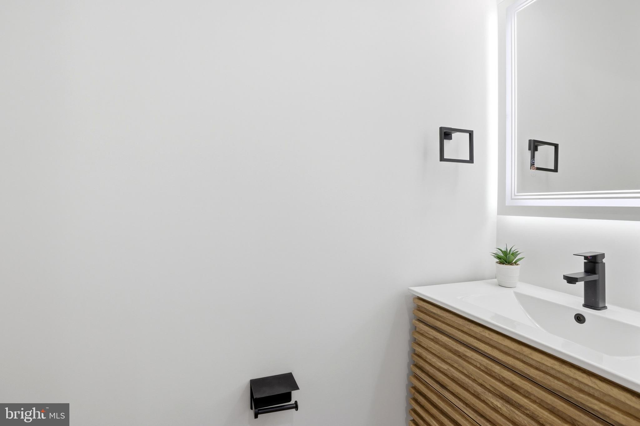 1140 Oates Street Northeast, Unit 101 Washington, DC 20002 - Photo 15 of 31 a bathroom with a sink and a mirror