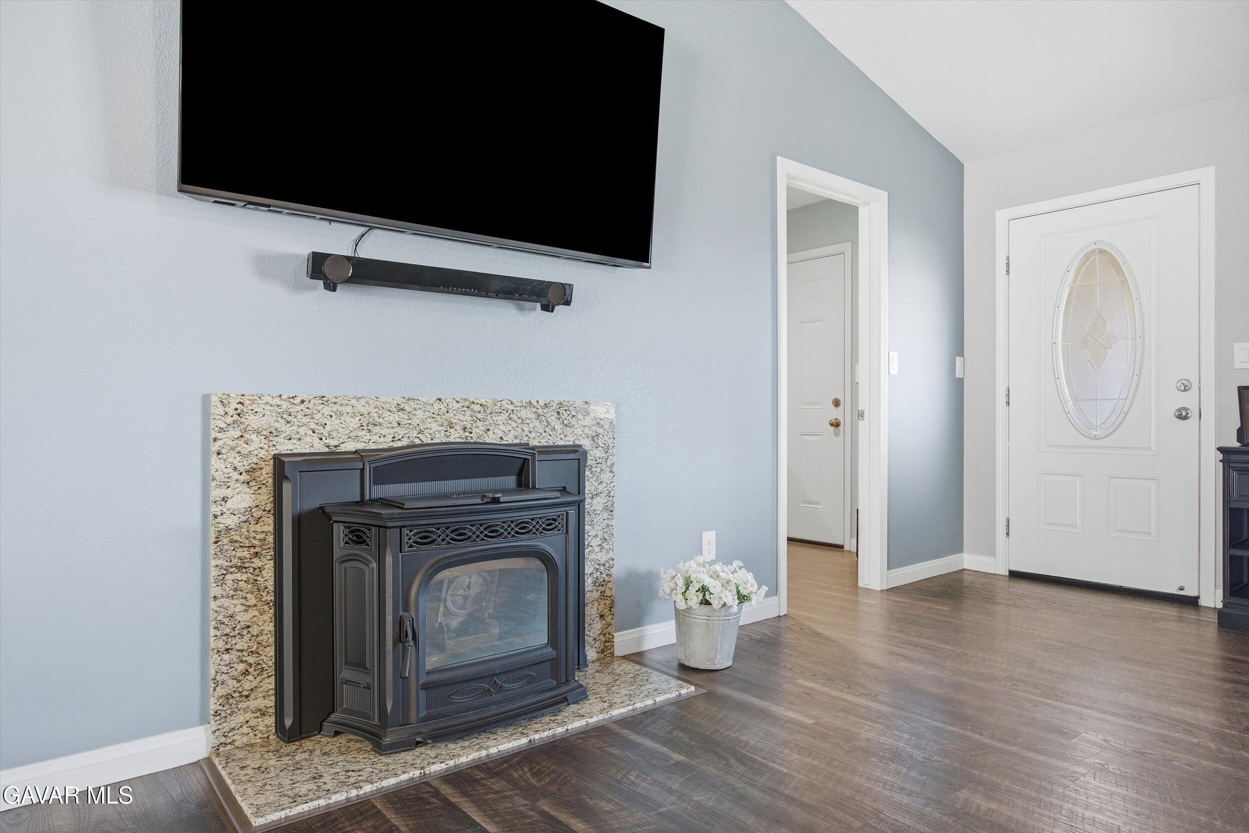 17820 Bold Venture Drive Tehachapi, CA 93561 - Photo 19 of 50 a living room with a fireplace a flat screen tv and a wooden floor