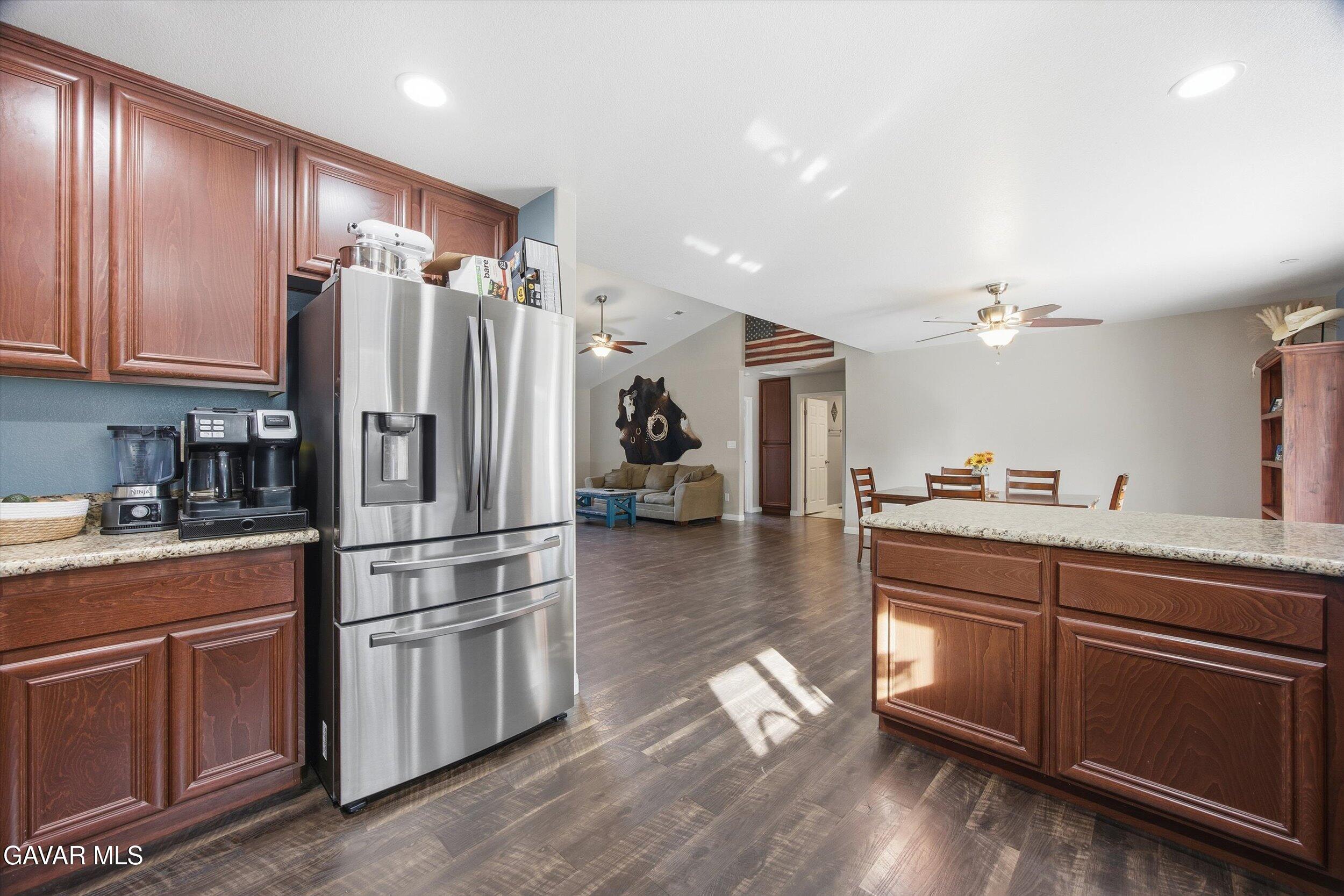 17820 Bold Venture Drive Tehachapi, CA 93561 - Photo 30 of 50 a kitchen with kitchen island wooden floors appliances and cabinets