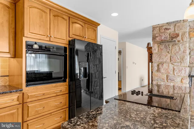 a kitchen with stainless steel appliances granite countertop a stove and cabinets