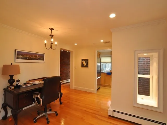 a view of a workspace with furniture and a window