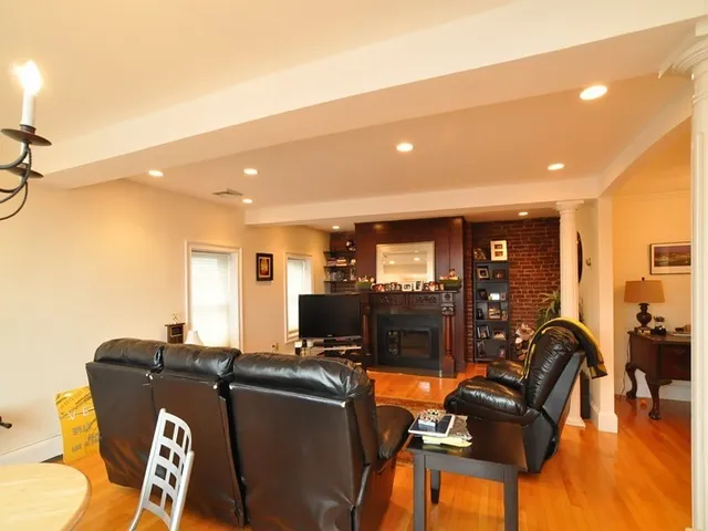 a living room with furniture a flat screen tv and floor to ceiling window