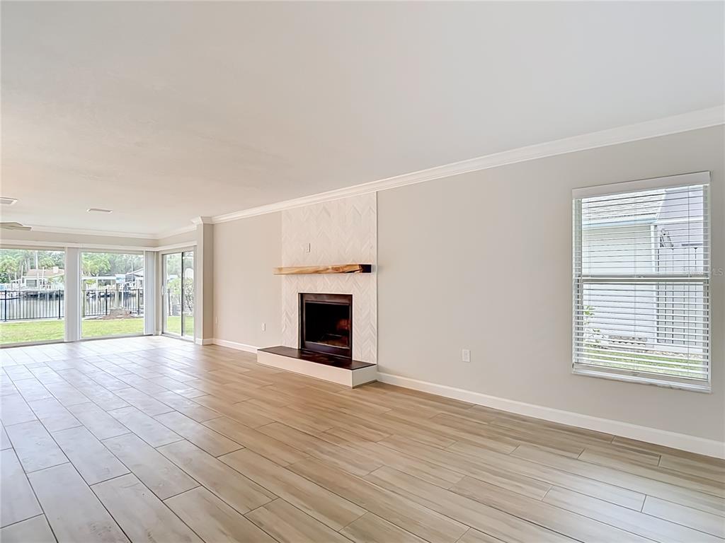4536 Mitcher Road New Port Richey, FL 34652 - Photo 28 of 46 a view of empty room with wooden floor and fireplace