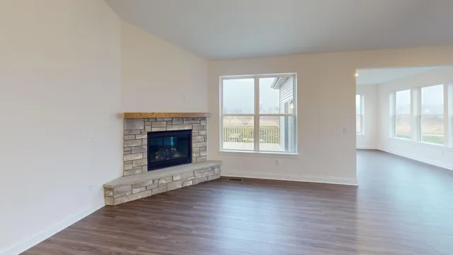 an empty room with wooden floor and fireplace