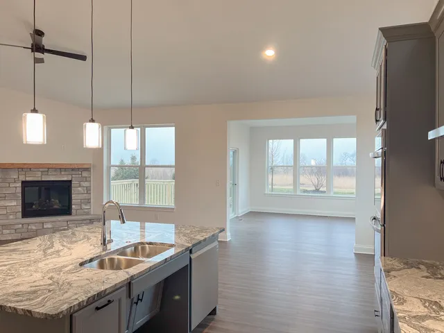 a kitchen with granite countertop a sink a counter top space and cabinets