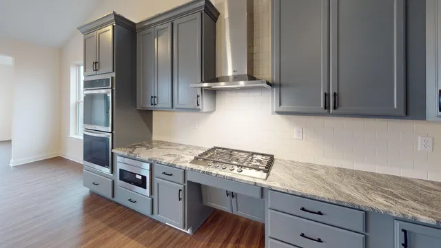 a kitchen with stainless steel appliances granite countertop a sink stove and cabinets