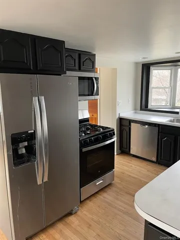 a kitchen with stainless steel appliances granite countertop a refrigerator and a stove top oven