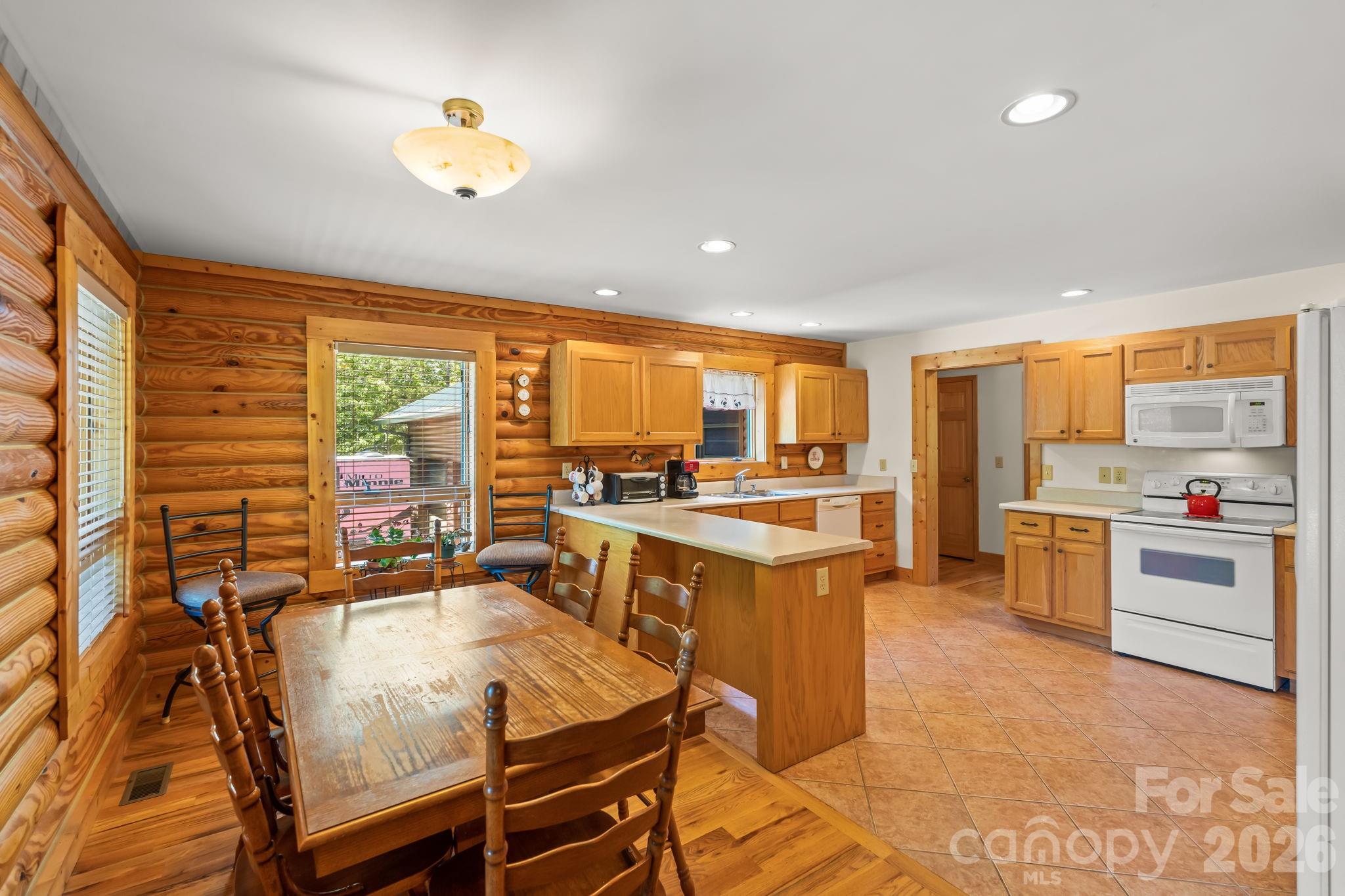 3341 Peniel Road Tryon, NC 28782 - Photo 13 of 48 a large dining hall with stainless steel appliances granite countertop a stove and a dining table view