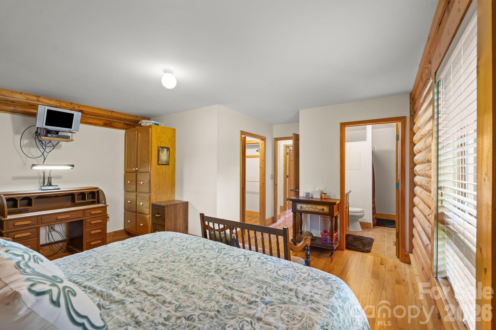 3341 Peniel Road Tryon, NC 28782 - Photo 23 of 48 a bedroom with a bed a large window and walk in closet