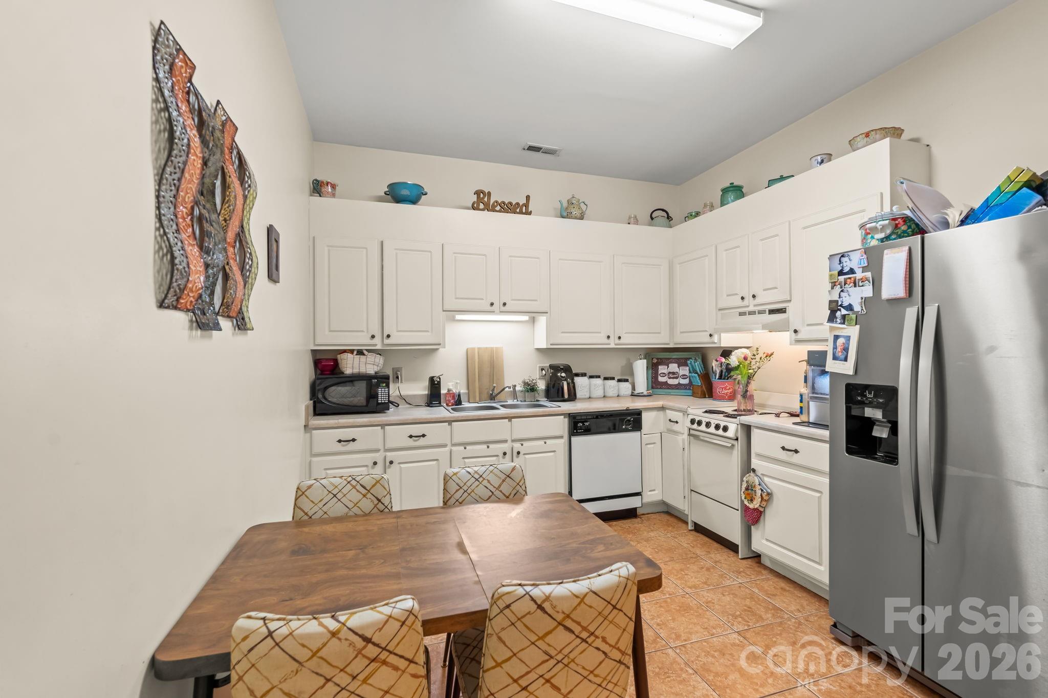 3341 Peniel Road Tryon, NC 28782 - Photo 35 of 48 a kitchen with white cabinets and stainless steel appliances