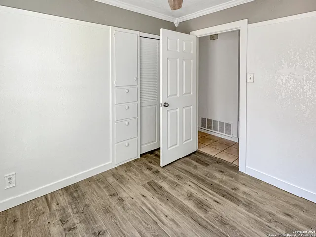 a view of an empty room with wooden floor