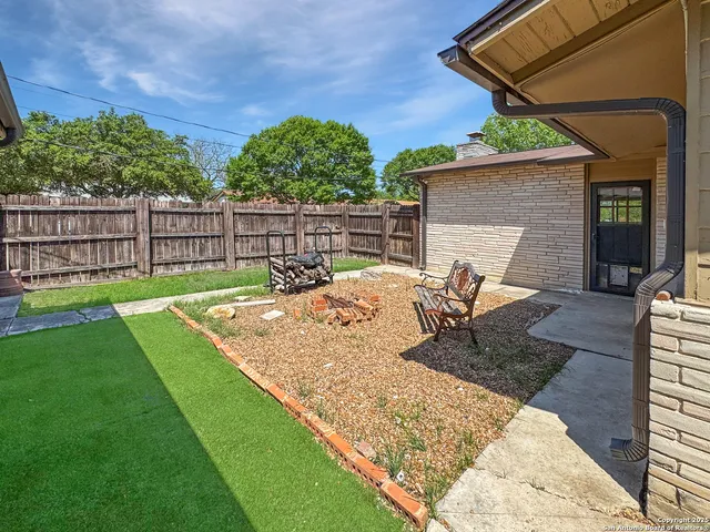 a view of a yard in front of a house with large tree