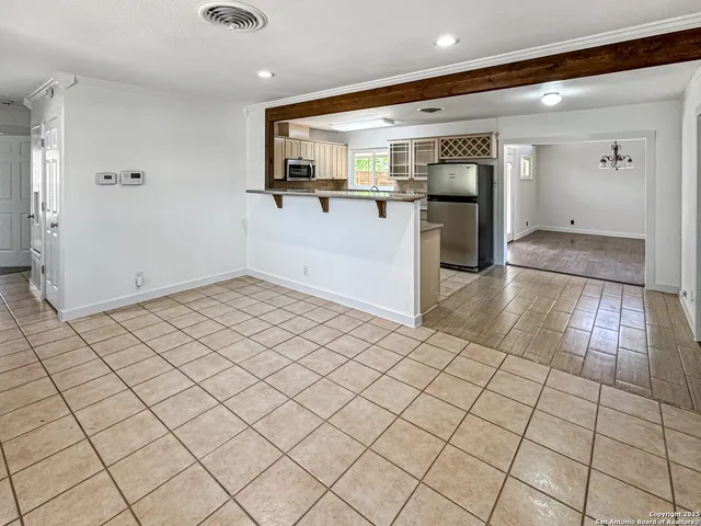 an empty room with kitchen view