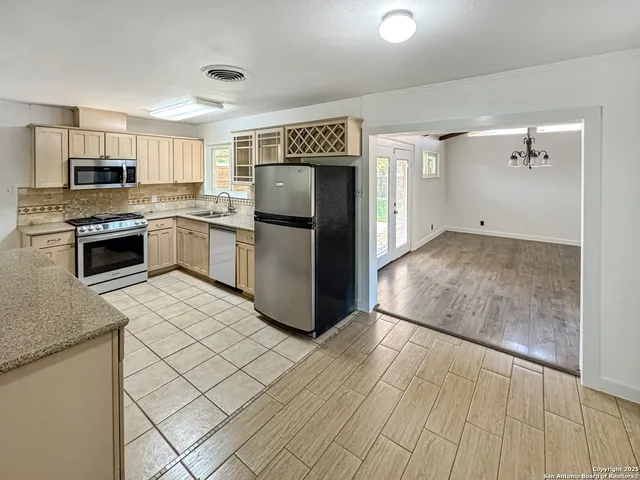 a kitchen with stainless steel appliances granite countertop a stove a sink and a microwave