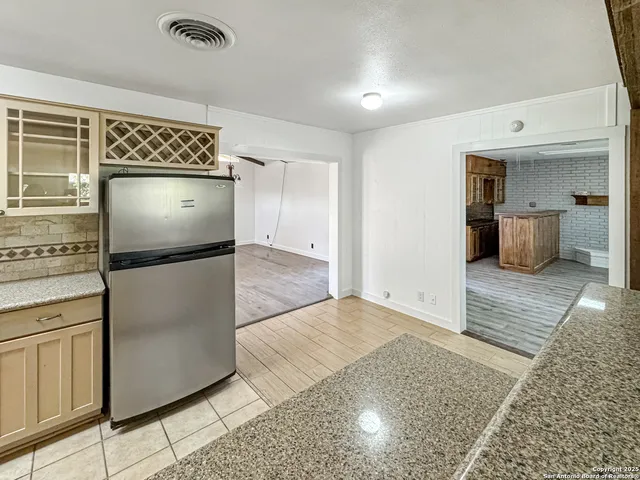 an empty room with wooden floor and cabinet
