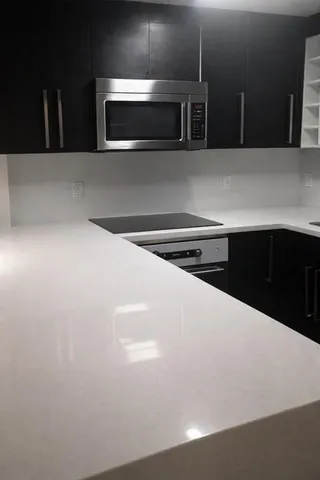 a kitchen with kitchen island a sink and microwave
