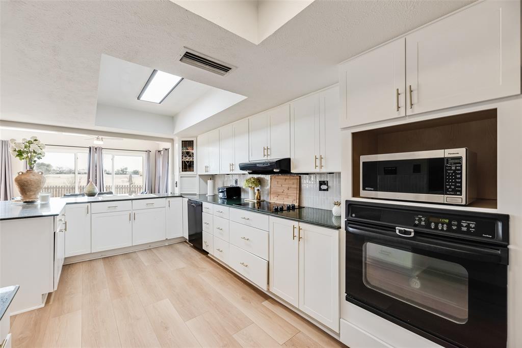 1954 Rambling Ridge Lane Carrollton, TX 75007 - Photo 8 of 23 a kitchen with stainless steel appliances kitchen island granite countertop a stove sink and cabinets