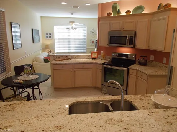 a kitchen with a sink a stove a microwave cabinets and dining table