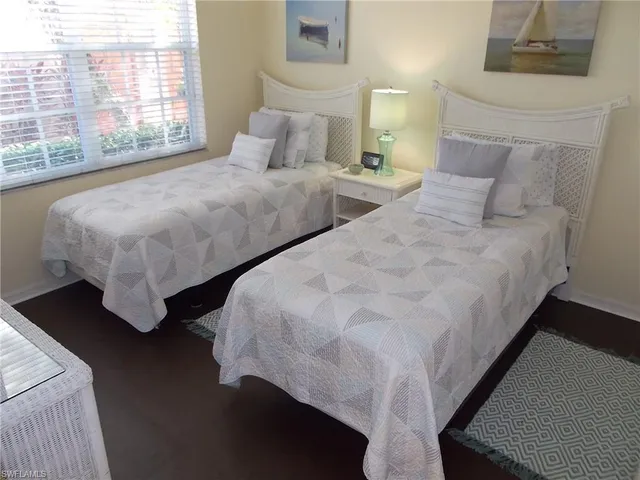 a large bed sitting in a bedroom next to a window